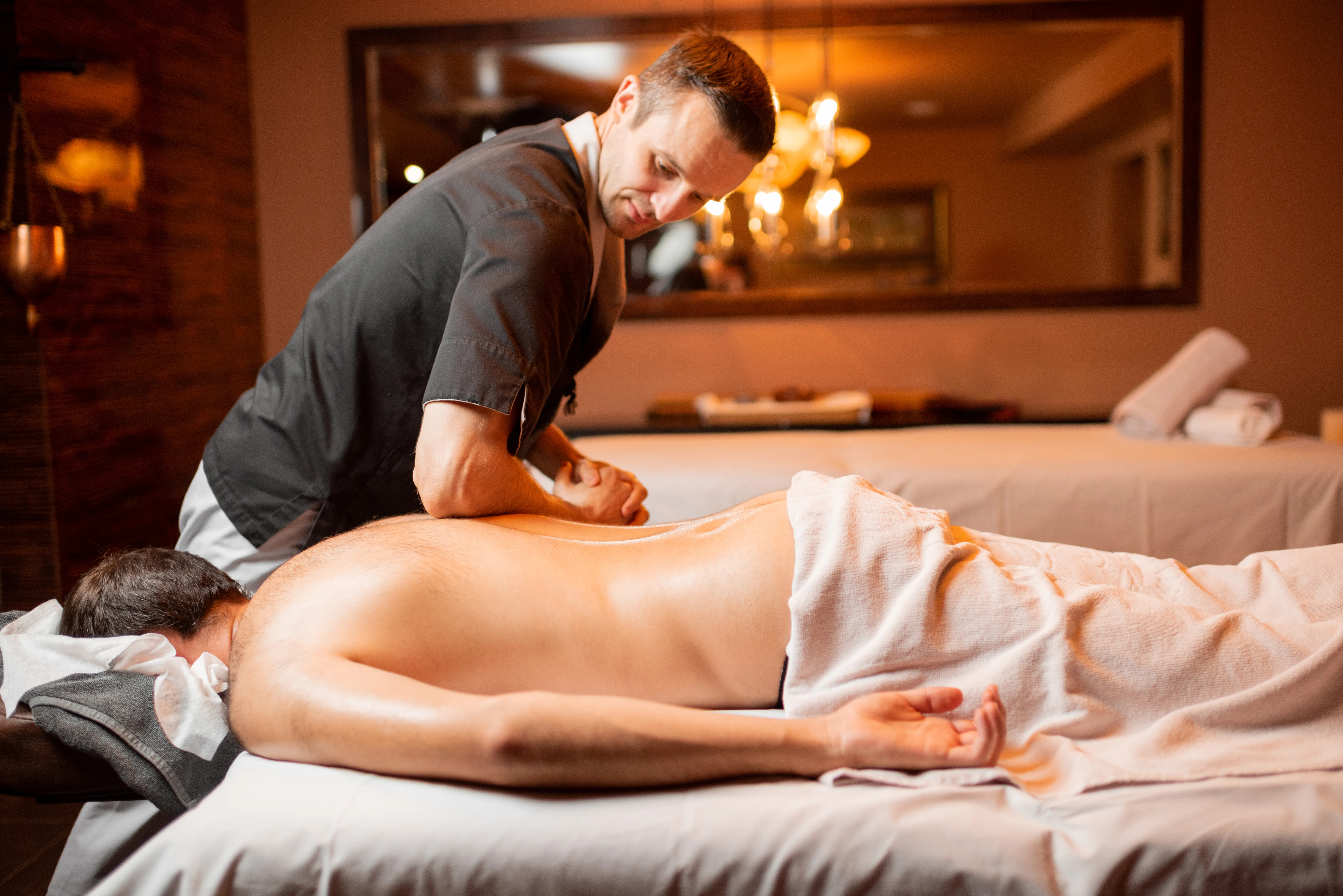 Masseur doing a deep massage to a male client
