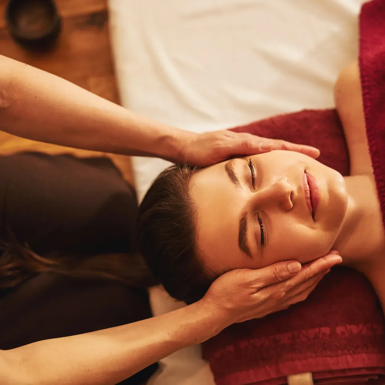 Face of satisfied lady receiving massage of cheeks
