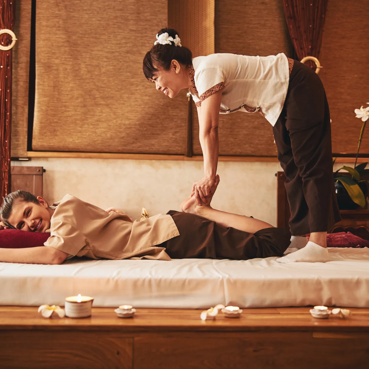 Professional Thai masseuse doing feet relaxation massage