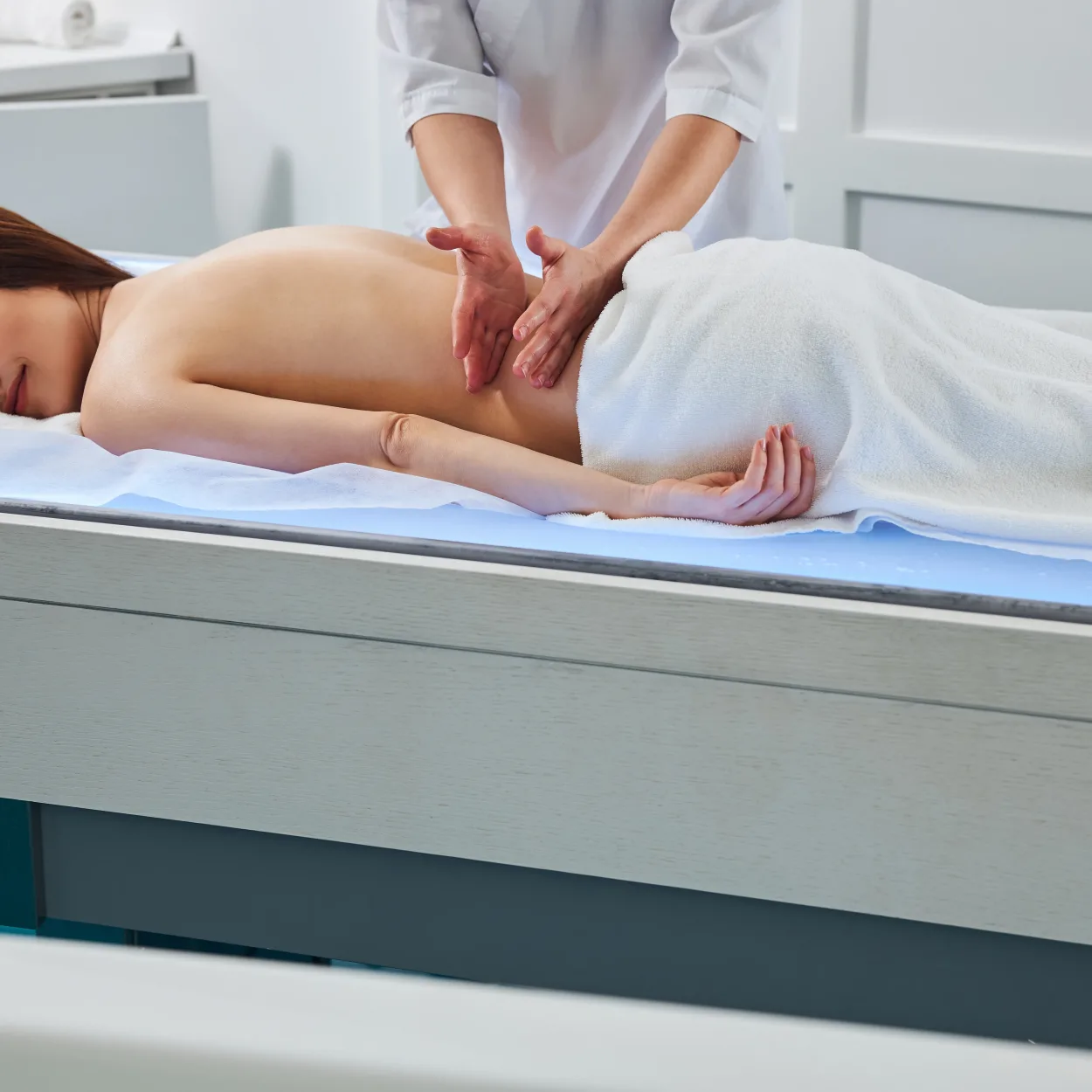 Specialist doing Swedish massage to female with tapotement technique Specialist doing Swedish massage to female with tapotement technique